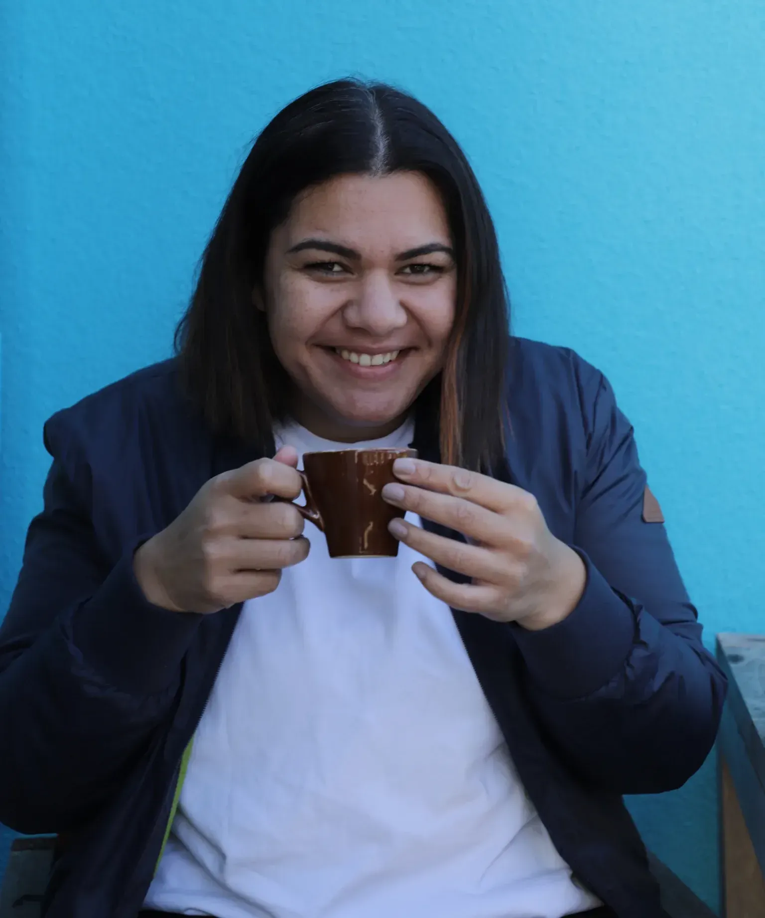 Lian Passmore looking straight down the camera, coffee in hand