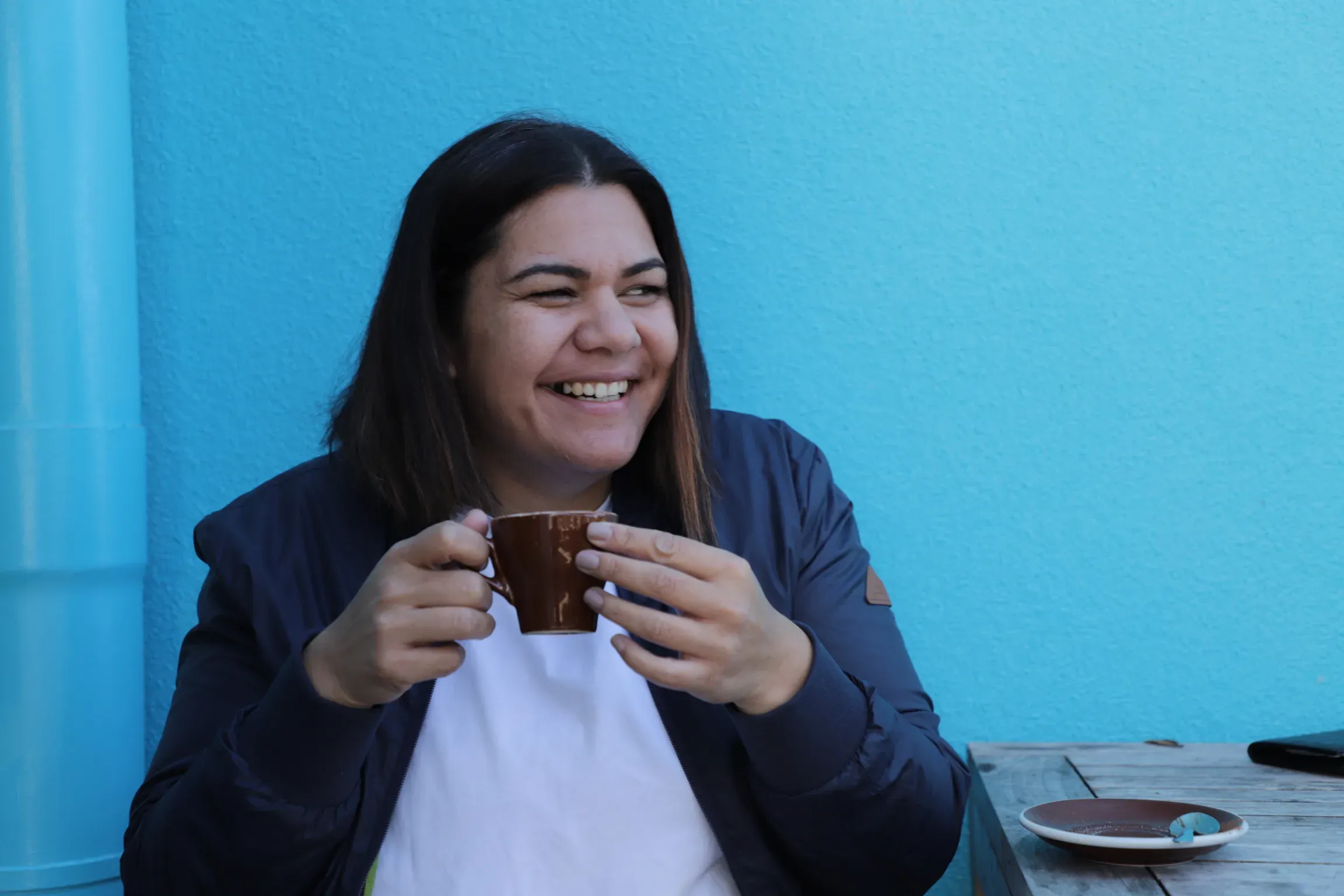 Lian Passmore laughing over a coffee at the blue wall